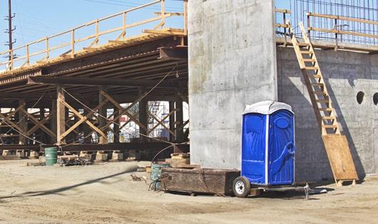 a row of modern portable restrooms at a busy work site, designed for easy use and maintenance